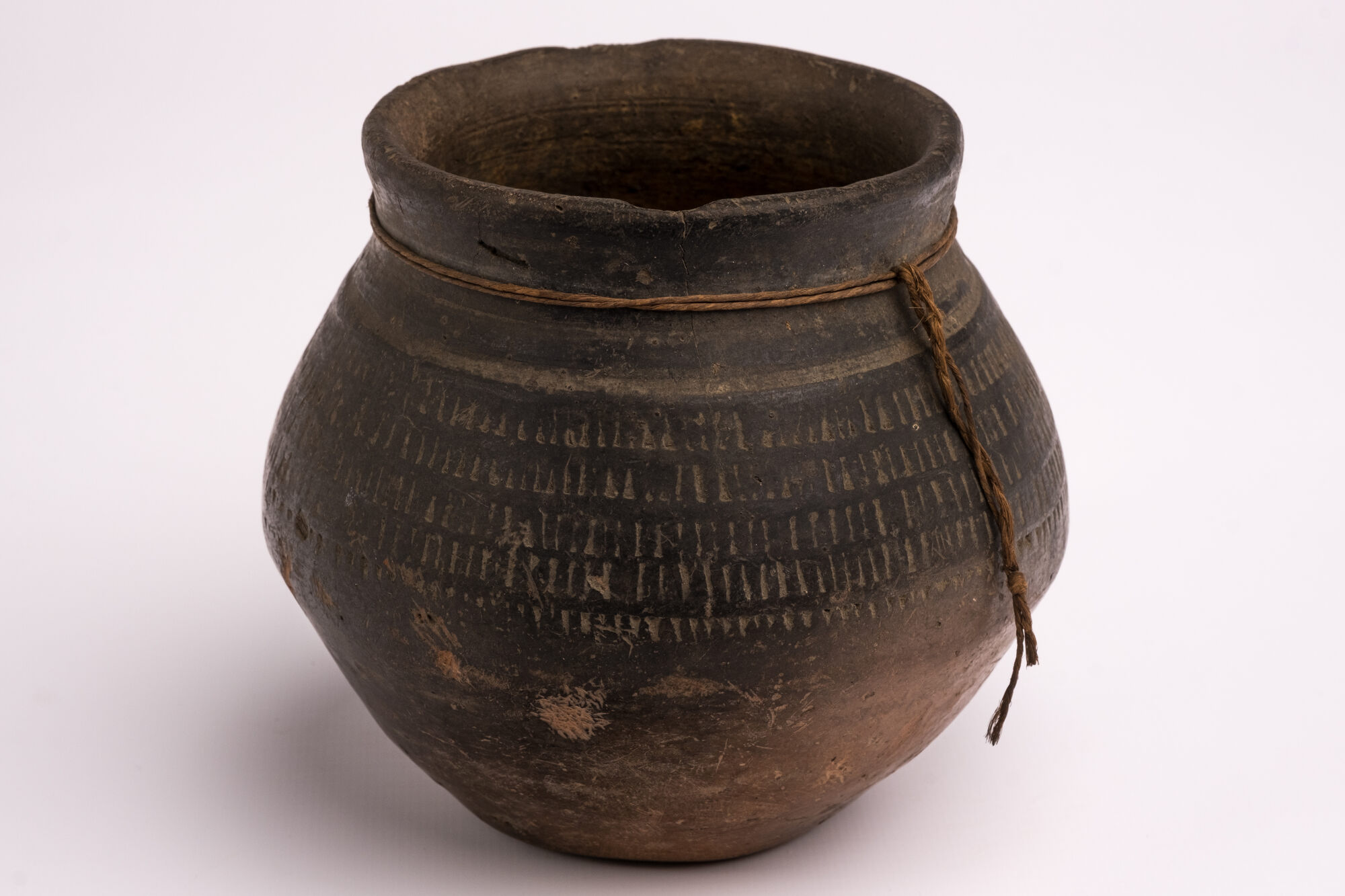 Biconische urne in reducerend gebakken en zwart gesmookt aardewerk