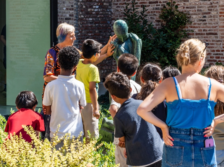Groep dat sculptuur aanraakt